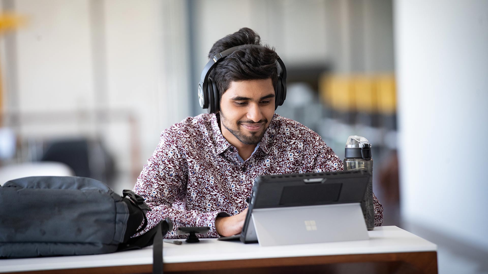 Man wearing headphones using a tablet computer